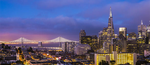 A photo of the Bay Bridge and San Francisco skyline at dusk